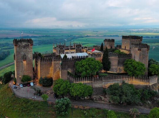 Aerial view of Almodovar Castle perched on green hilltop