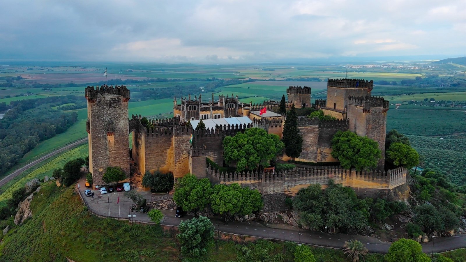 Aerial view of Almodovar Castle perched on green hilltop