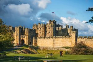 Alnwick Castle exterior under blue sky with flag