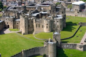 Aerial photo of Alnwick Castle's stone walls and green courtyards
