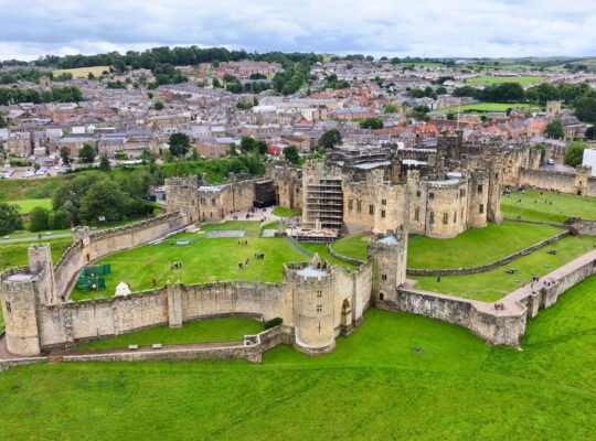 Aerial view of Alnwick Castle within town and green outer bailey