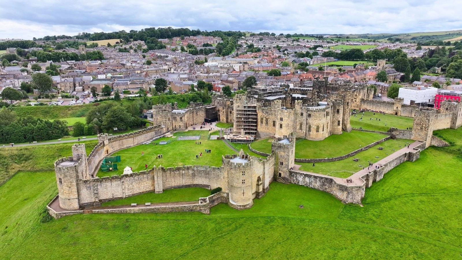 Aerial view of Alnwick Castle within town and green outer bailey