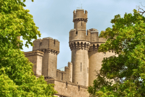 Arundel Castle stone towers framed by green trees in West Sussex.