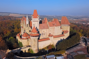 Aerial view of Burg Kreuzenstein, a medieval revival castle above Leobendorf, Lower Austria, surrounded by autumn forests.
