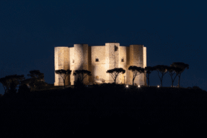 Castel del Monte illuminated at night atop a hill in Andria, Puglia, Italy.