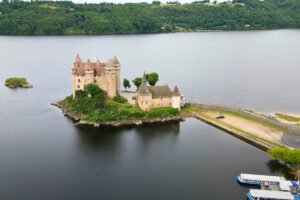 Aerial view of Chateau de Val island castle surrounded by lake