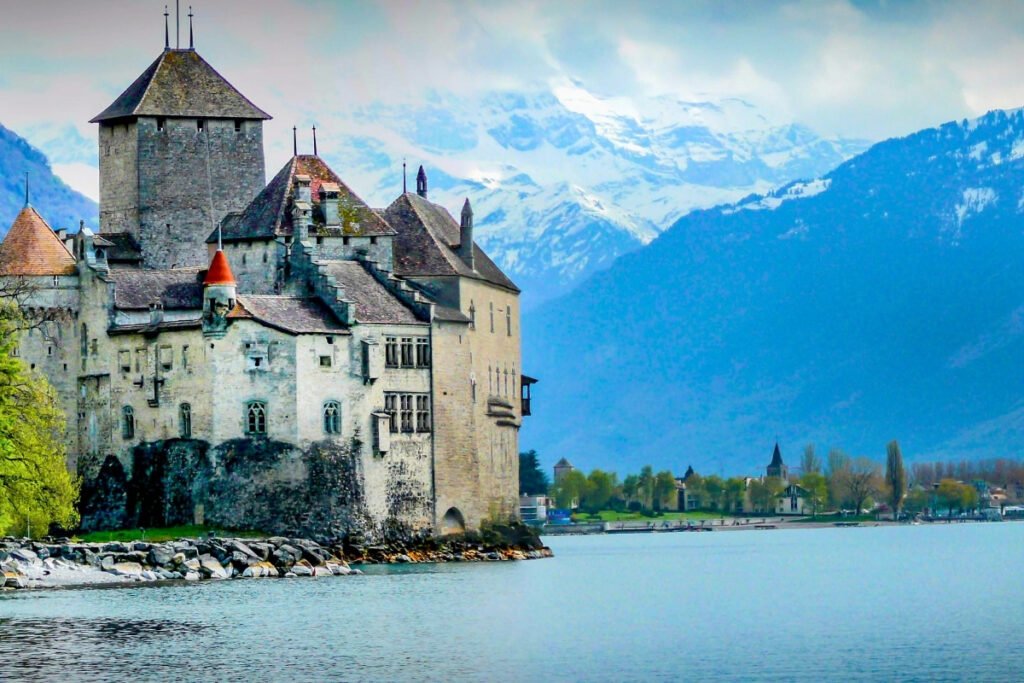 Chillon Castle beside Lake Geneva with snowy Alps backdrop