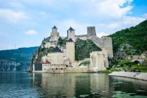 Golubac Fortress on Danube cliffs, towers reflected in calm water