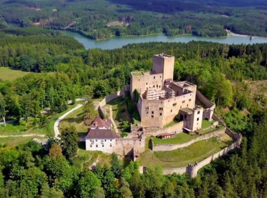 Aerial view of Landštejn Castle amid trees and reservoir