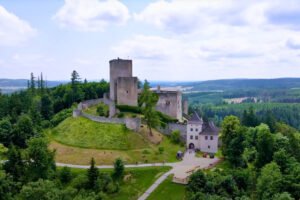 Aerial view of Landštejn Castle atop a green hill