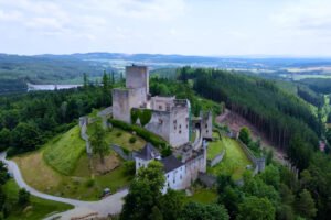Aerial view of Landštejn Castle atop a wooded hill