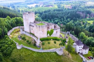 Aerial view of Landštejn Castle perched above dense Bohemian forest