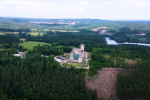 Aerial view of Landštejn Castle on hill surrounded by forest and lake