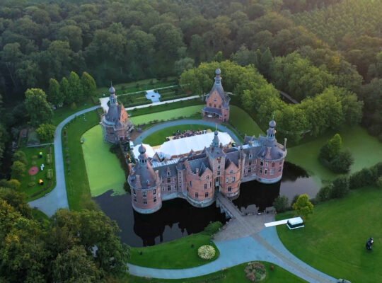 Aerial view of Ooidonk Castle surrounded by moat and forest
