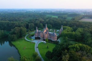 Aerial view of Ooidonk Castle surrounded by moat and forest