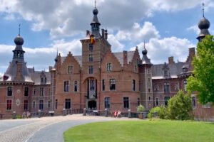 Ooidonk Castle manor with towers and park under blue sky