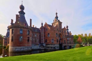 Ooidonk Castle red-brick chateau beside moat and green lawn