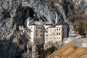 Predjama Castle built into a limestone cliff in Slovenia, medieval fortress merging with a vast cave mouth.
