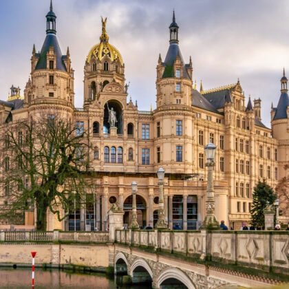 Schwerin Castle reflected in calm moat with ornate bridges and towers