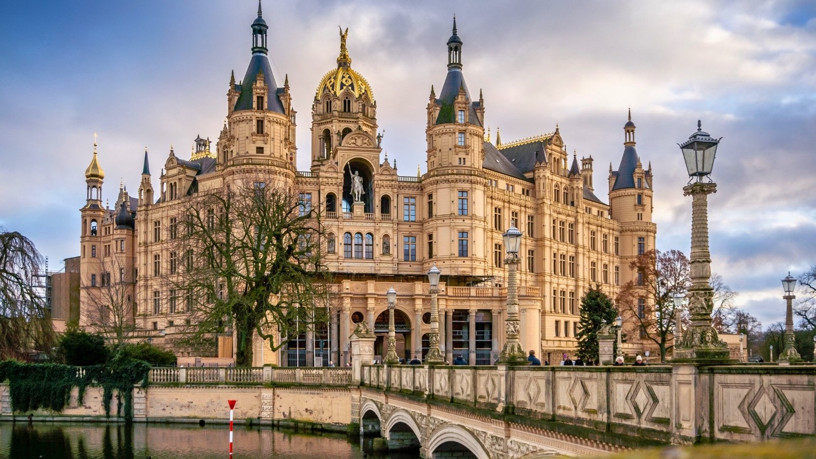 Schwerin Castle reflected in calm moat with ornate bridges and towers