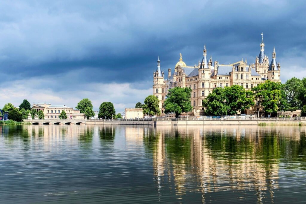 Schwerin Castle reflected on calm lake under dramatic sky