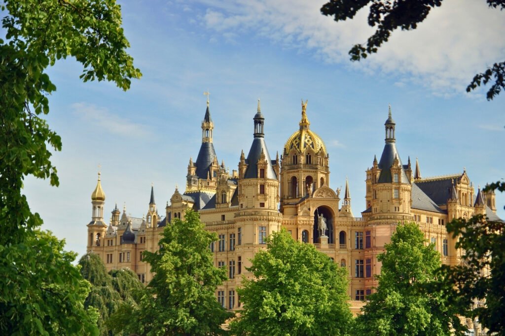 Schwerin Castle framed by trees under a clear blue sky