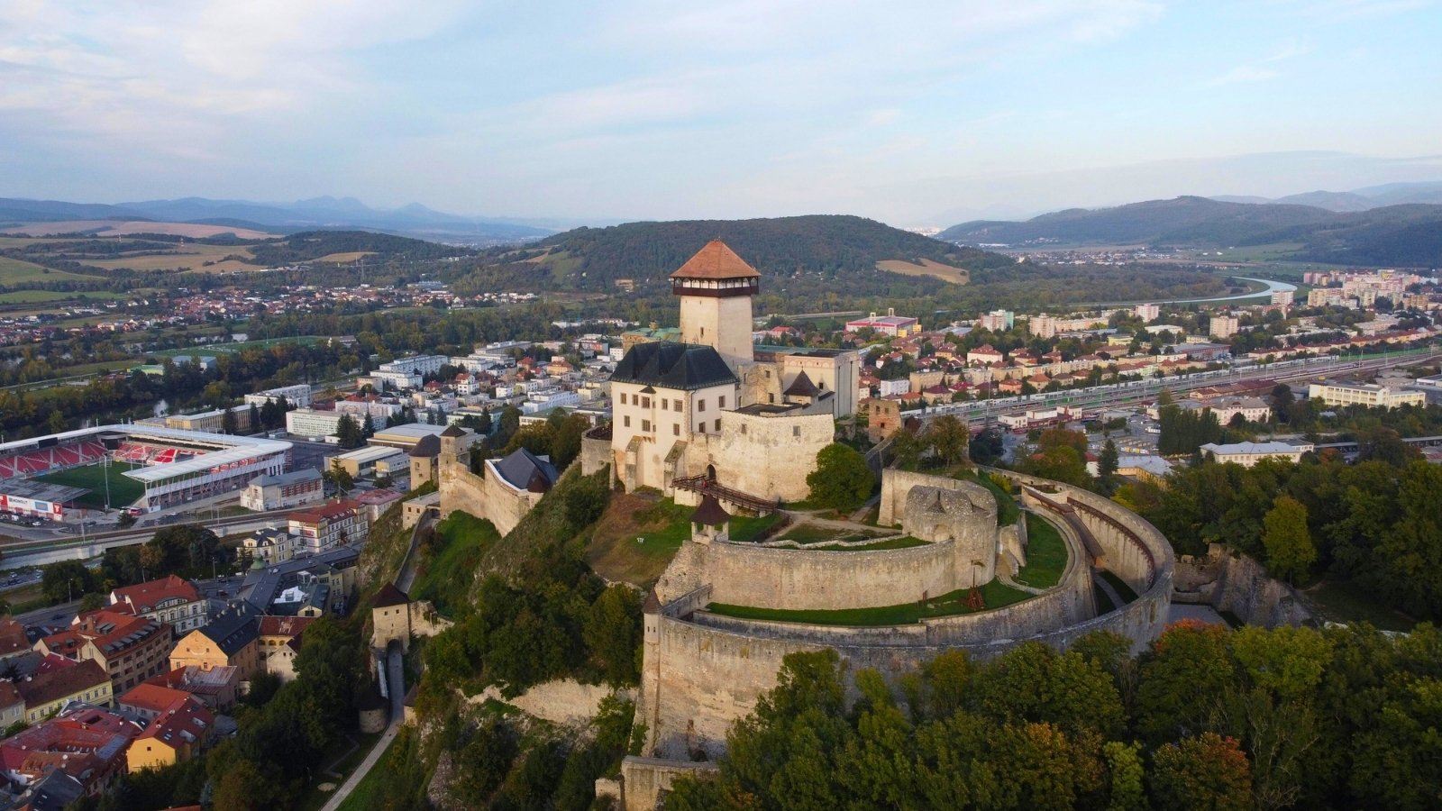 Aerial view of Trenčín Castle perched above town and stadium