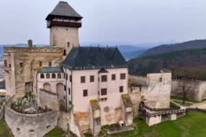Trencin Castle perched above town with walls and tower, distant hills
