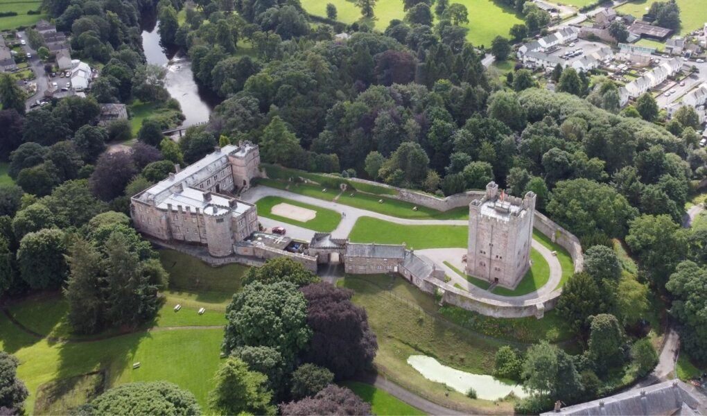 Aerial view of Appleby Castle surrounded by trees and river