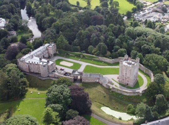 Aerial view of Appleby Castle surrounded by trees and river
