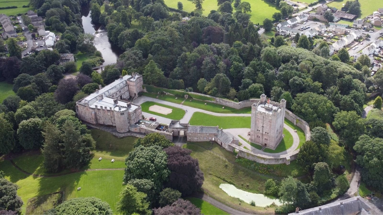 Aerial view of Appleby Castle surrounded by trees and river