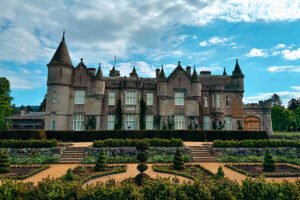 Balmoral Castle facade with manicured gardens and blue sky