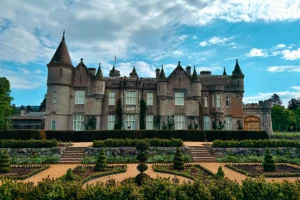 Balmoral Castle facade with manicured gardens and blue sky