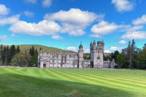 Balmoral Castle facade and manicured lawn under blue sky