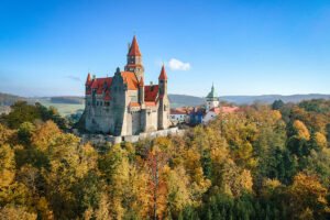 Bouzov Castle on hill surrounded by autumn forest