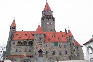 Bouzov Castle stone facade with red-tiled roofs and central tower