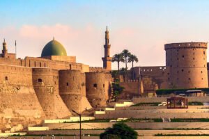 Cairo Citadel stone walls, domes and minaret at sunset