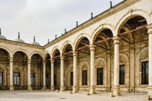 Stone arches and columns in a Cairo Citadel courtyard under soft daylight