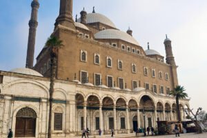 Facade and domes of Cairo Citadel mosque with visitors