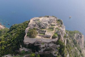 Aerial view of Castello bizantino di Angelokastro perched above turquoise Ionian Sea