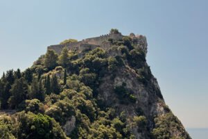 Castello bizantino di Angelokastro atop rocky coastal cliff surrounded by trees