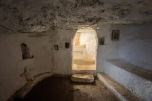 Small cave chapel inside Castello bizantino di Angelokastro with whitewashed walls and arched doorway