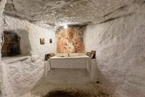 Interior small whitewashed chapel at Castello bizantino di Angelokastro with frescoed altar