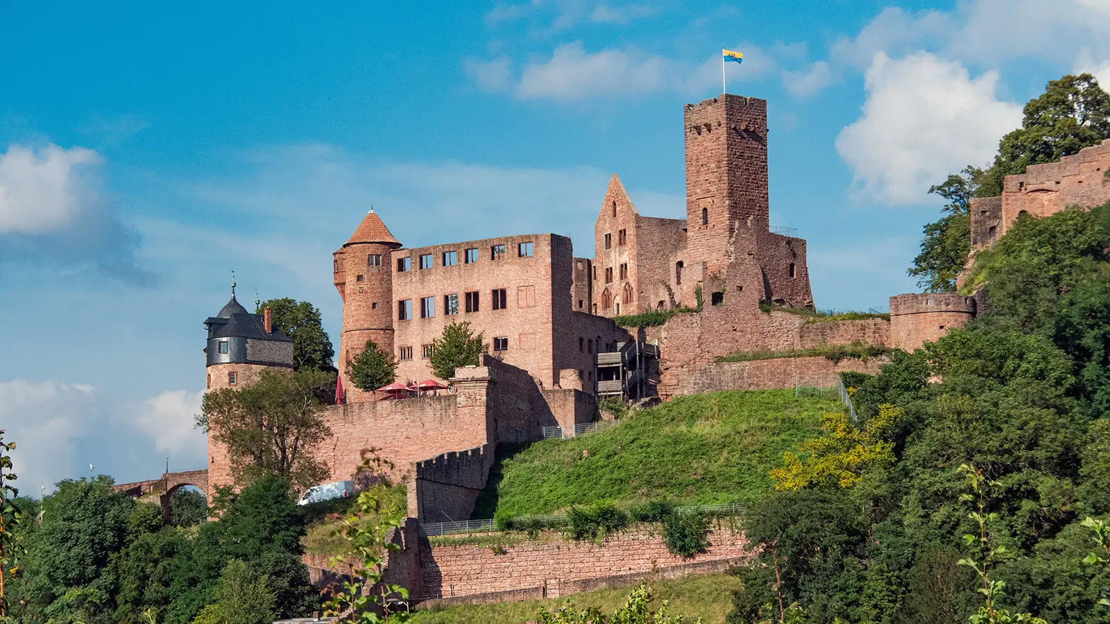 Castle Wertheim ruins on a sunlit hillside overlooking greenery