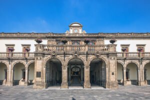 Chapultepec Castle stone arches and clock tower under blue sky