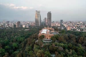 Aerial view of Chapultepec Castle atop green hill, Mexico City skyline