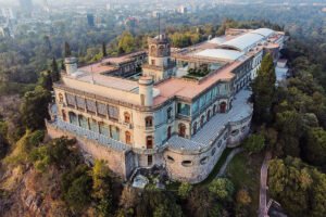 Aerial view of Chapultepec Castle perched above urban forest in Mexico City