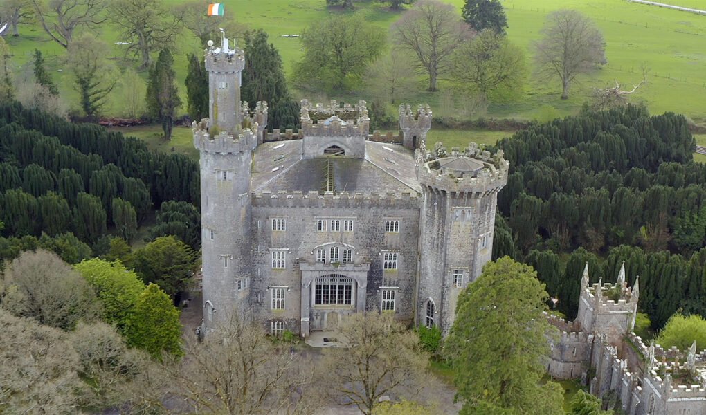 Aerial view of Charleville Castle surrounded by yew trees and Irish flag