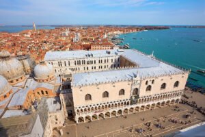 Aerial shot of the Doge's Palace and Venetian lagoon, rooftops and domes