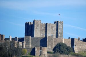 Dover Castle keep on hilltop with flag, clear blue sky